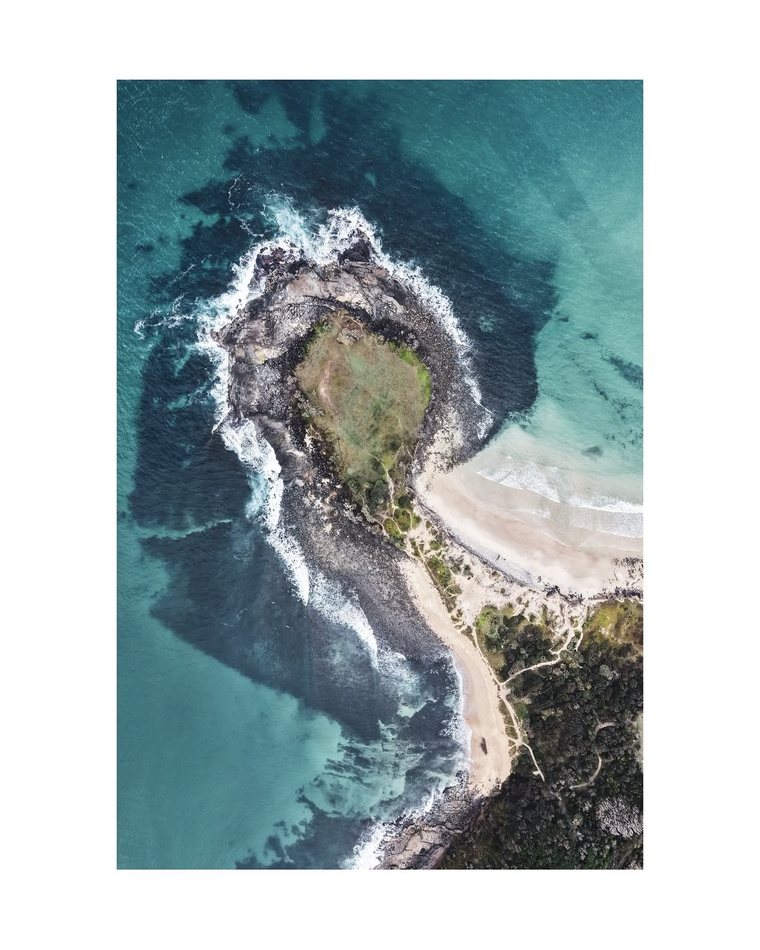 Aerial view of a rocky headland and turquoise water